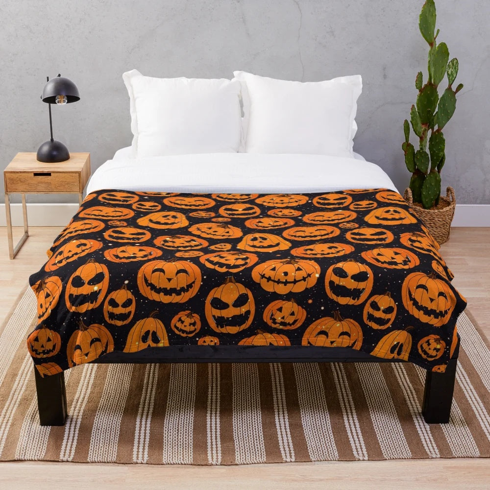 Plush blanket featuring smiling pumpkins on a starry night background