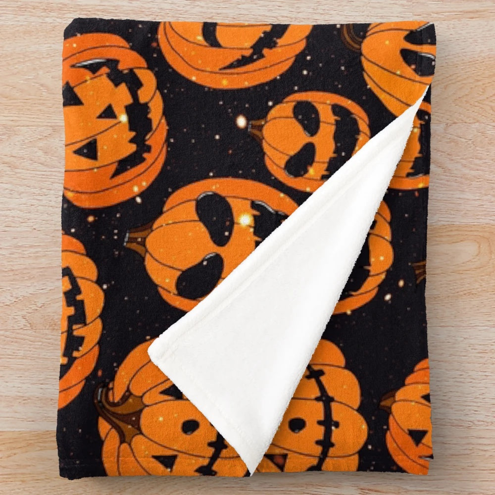 Plush blanket featuring smiling pumpkins on a starry night background