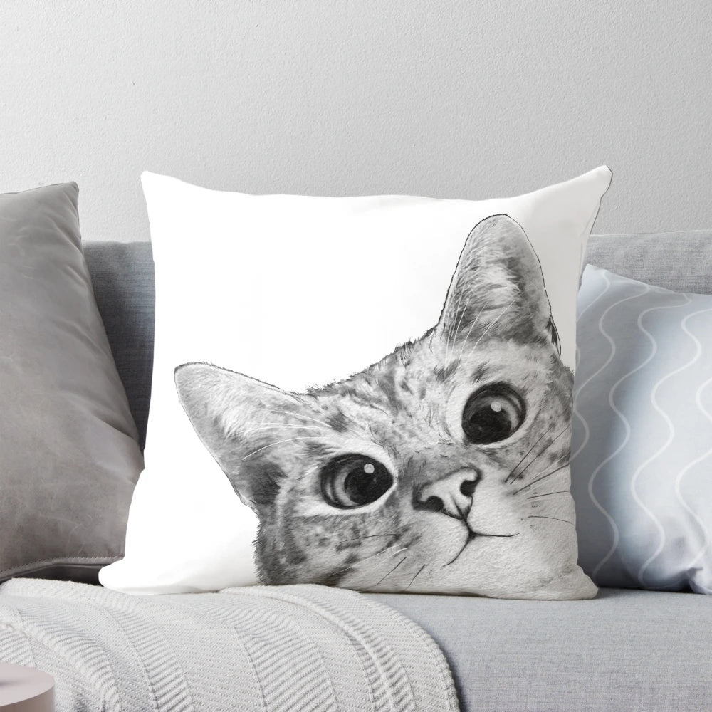 A black and white cat peeking out from a plush, comfortable pillow