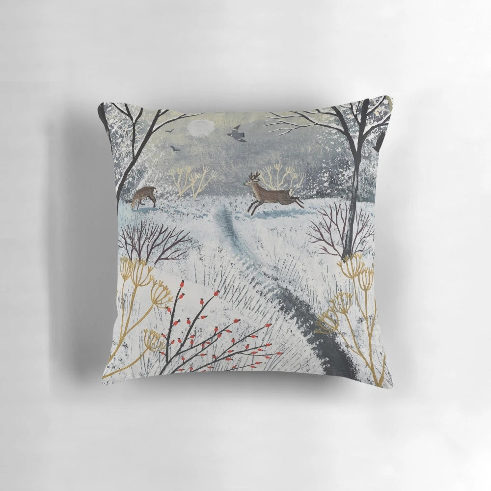 A soft, plush pillow featuring a peaceful snow scene with deer in a winter landscape.
