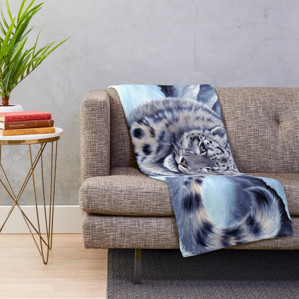 A cozy plush blanket featuring a beautiful snow leopard design by artist Roz Thompson