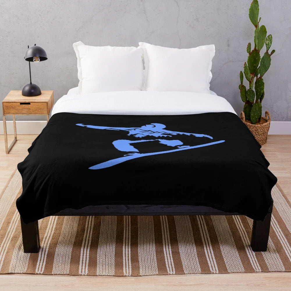 Snowboarding silhouette on plush blanket with snowy mountains