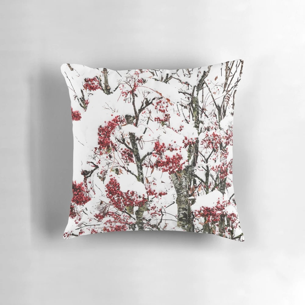 A decorative pillow featuring a minimalist design of snowy berries and branches