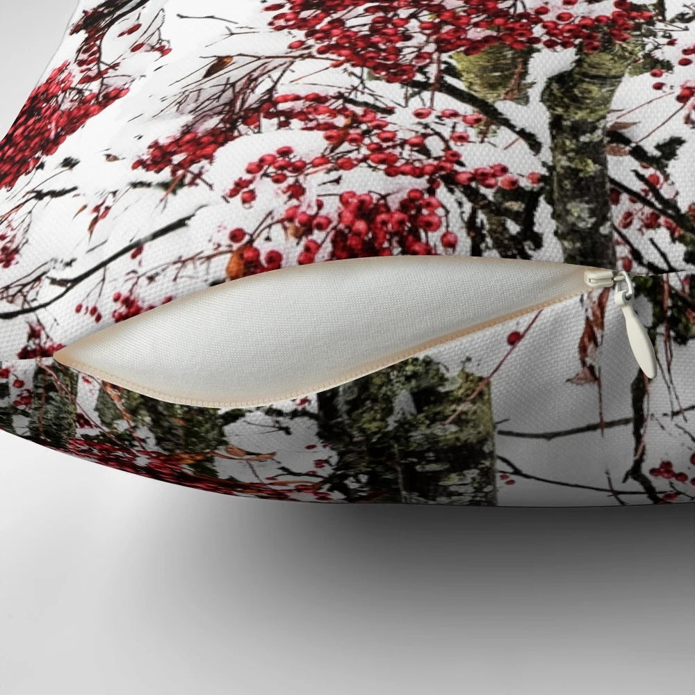 A decorative pillow featuring a minimalist design of snowy berries and branches
