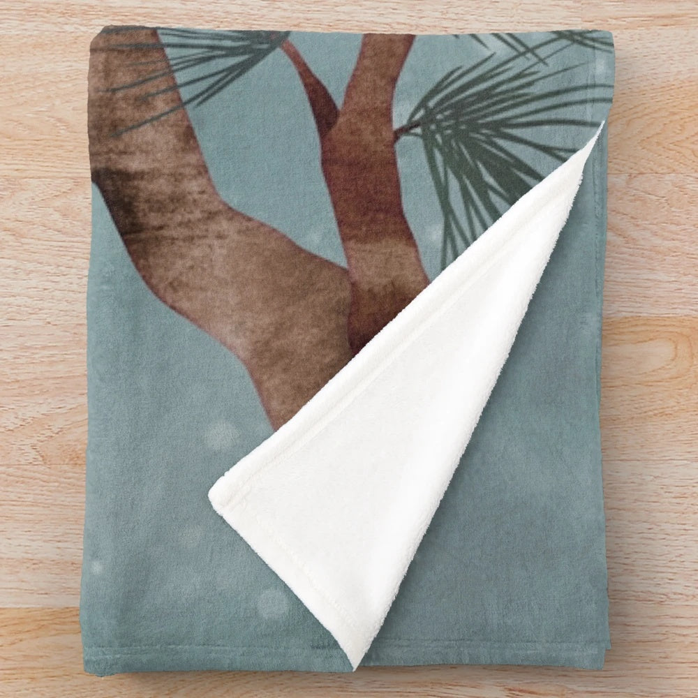 Snowy plush blanket with pine needles and winter scenery