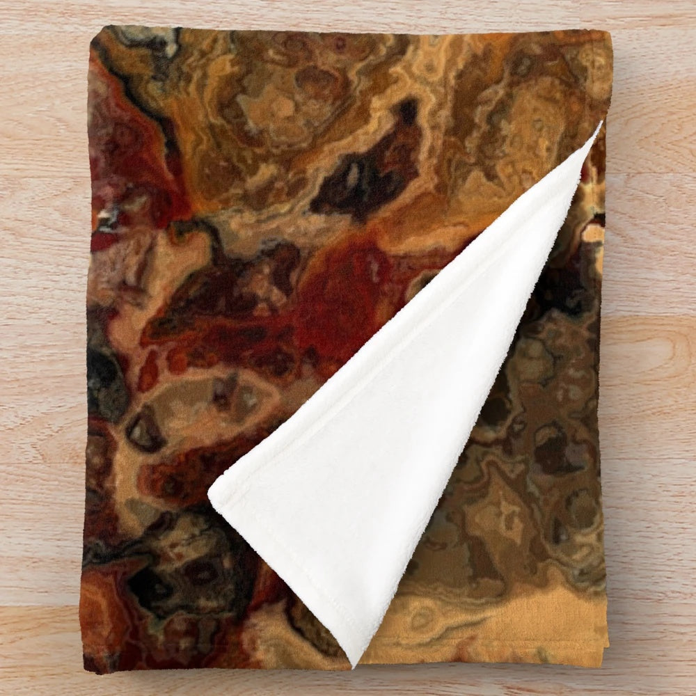 Red, black and rust colored plush blanket with an abstract marble design