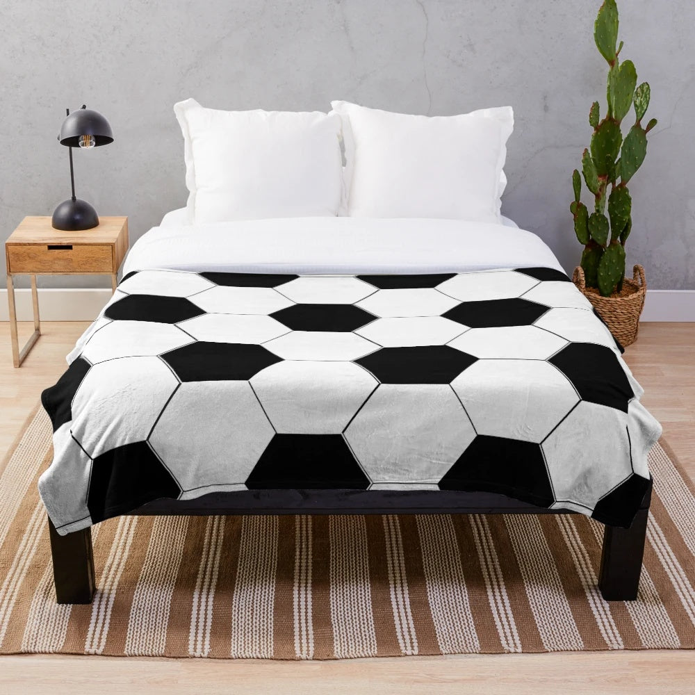 Plush blanket with a soccer ball/football design in black and white hexagon pattern