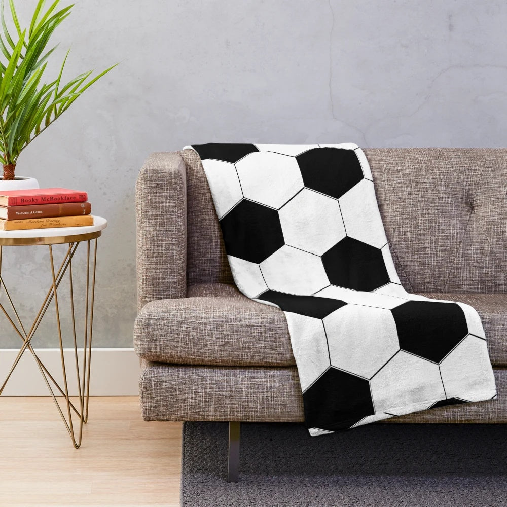 Plush blanket with a soccer ball/football design in black and white hexagon pattern