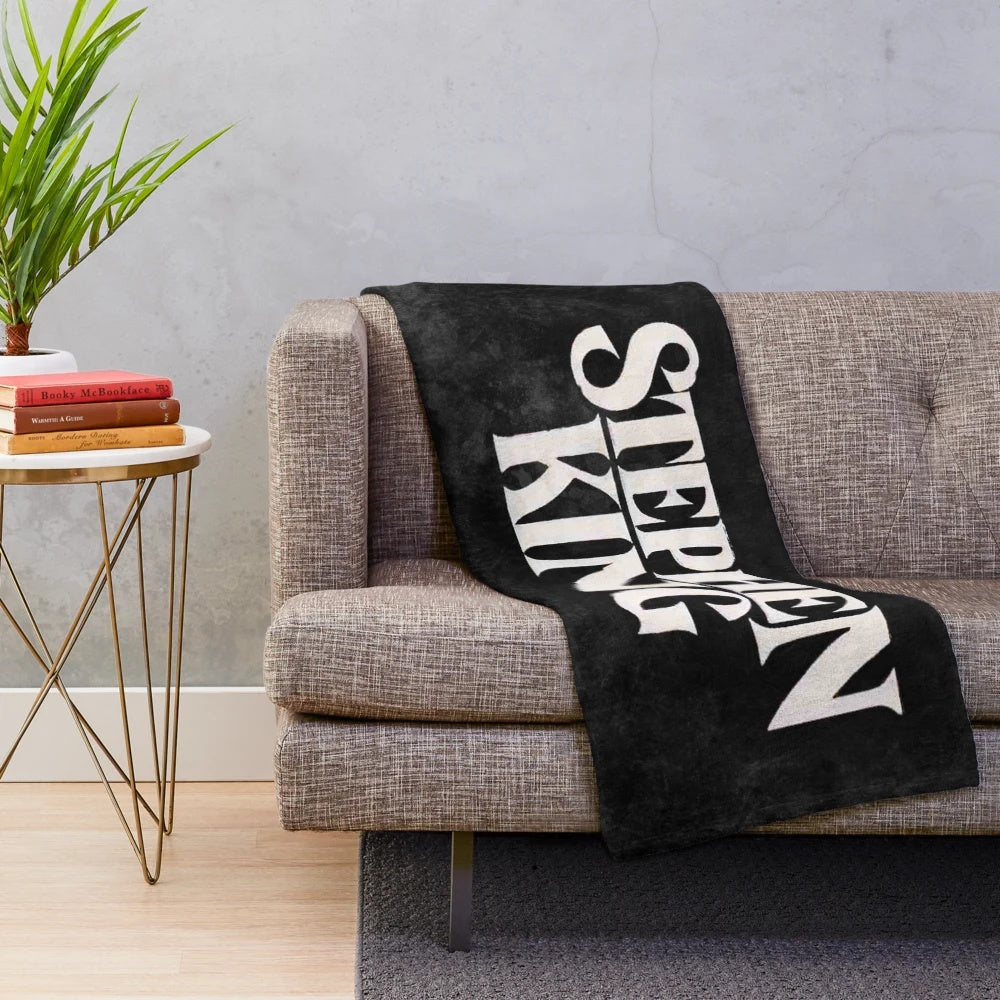 Stephen King-inspired plush blanket featuring book covers and horror movie imagery