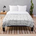 Sudoku-inspired plush blanket with a white background and bold, black grid pattern