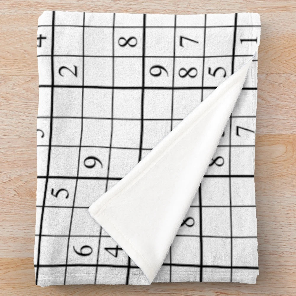 Sudoku-inspired plush blanket with a white background and bold, black grid pattern