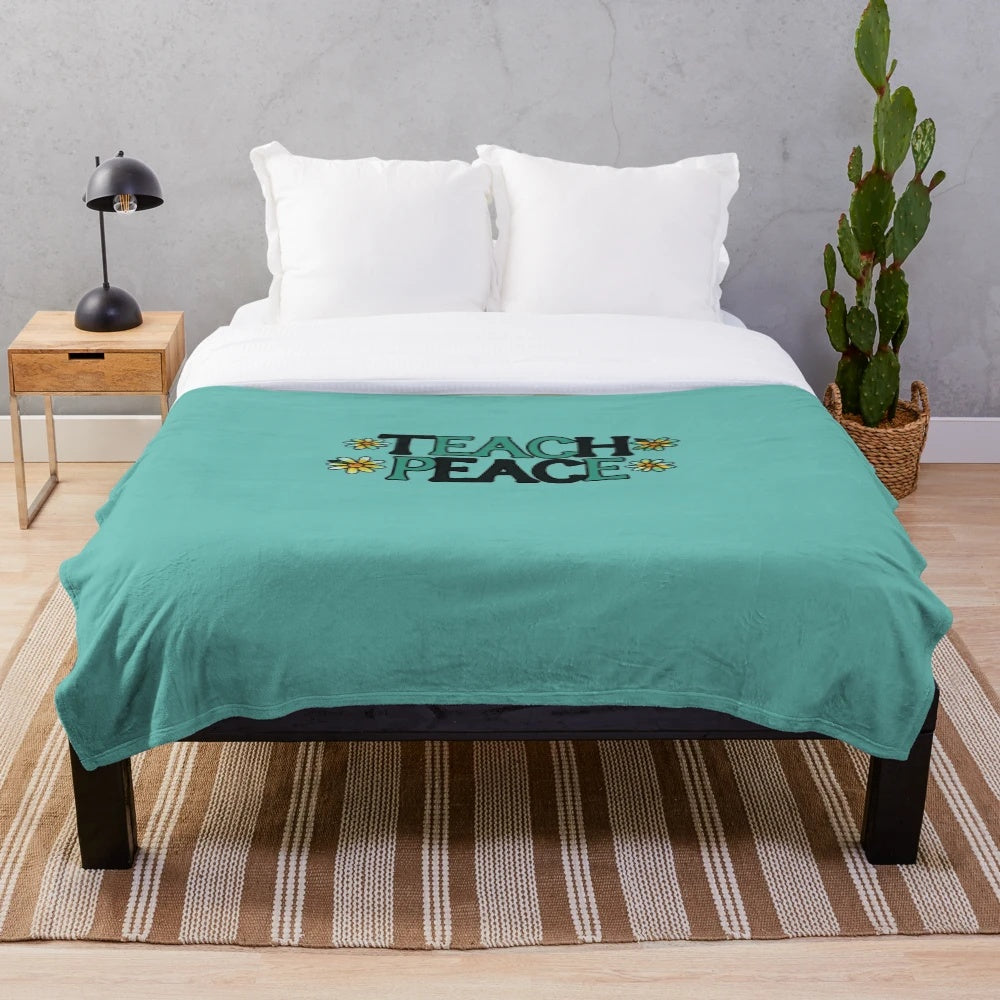 Soft plush blanket with "Teach Peace" design, perfect for educational settings and home decor.