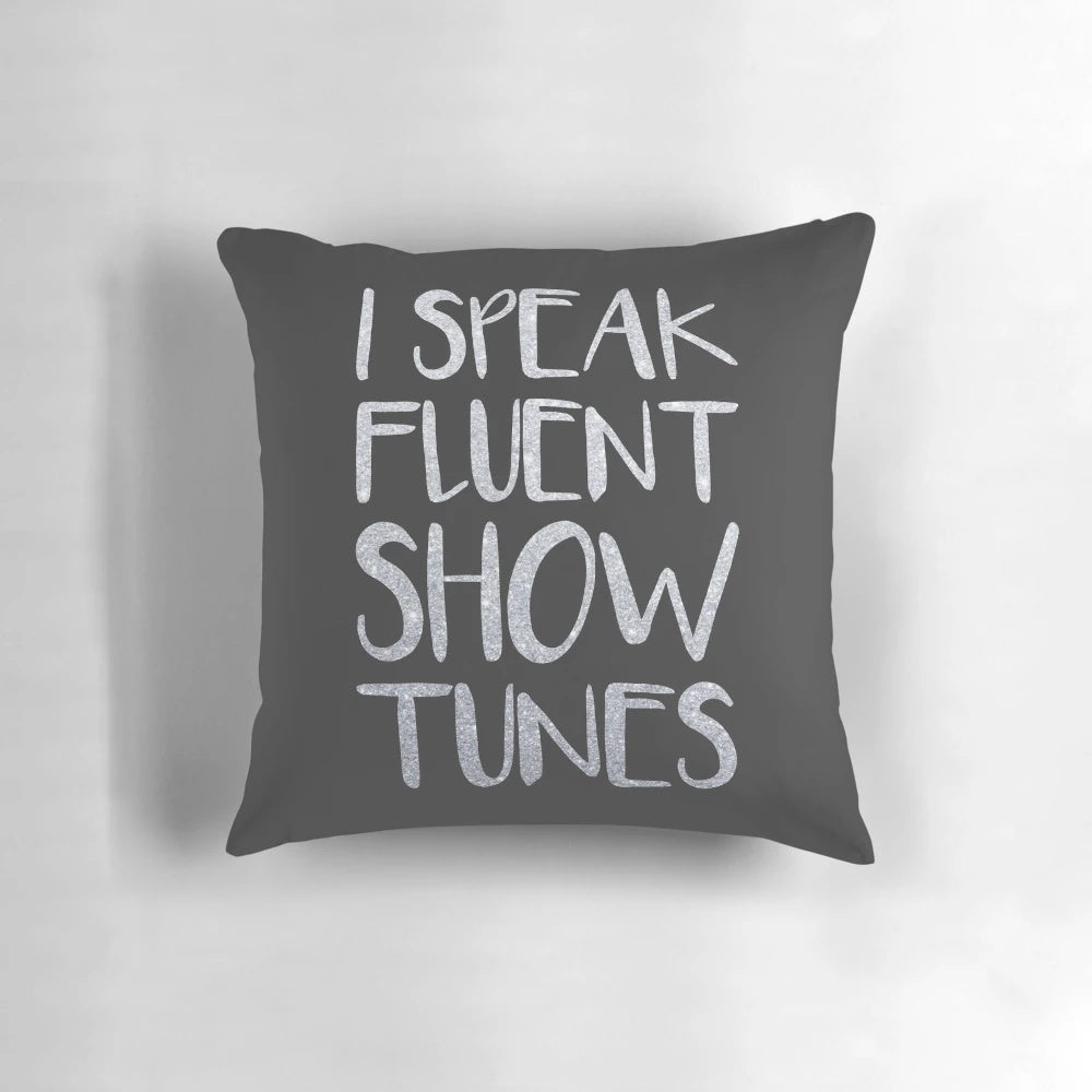 A plush pillow featuring the text "I Speak Fluent Showtunes" against a theatre-inspired background.