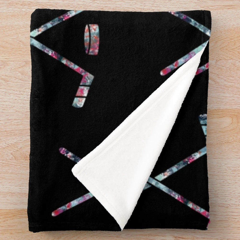Plush blanket featuring hockey sticks in the colors of the Seattle Kraken NHL team