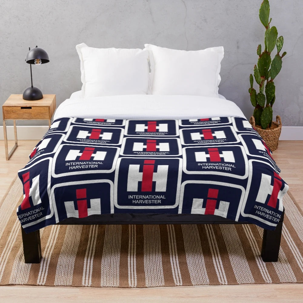Tractor-inspired plush blanket with farm equipment logos