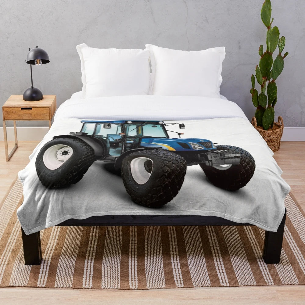 A soft and plush blue blanket featuring a tractor design, perfect for adding farmhouse style to your home.