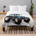 A soft and plush blue blanket featuring a tractor design, perfect for adding farmhouse style to your home.