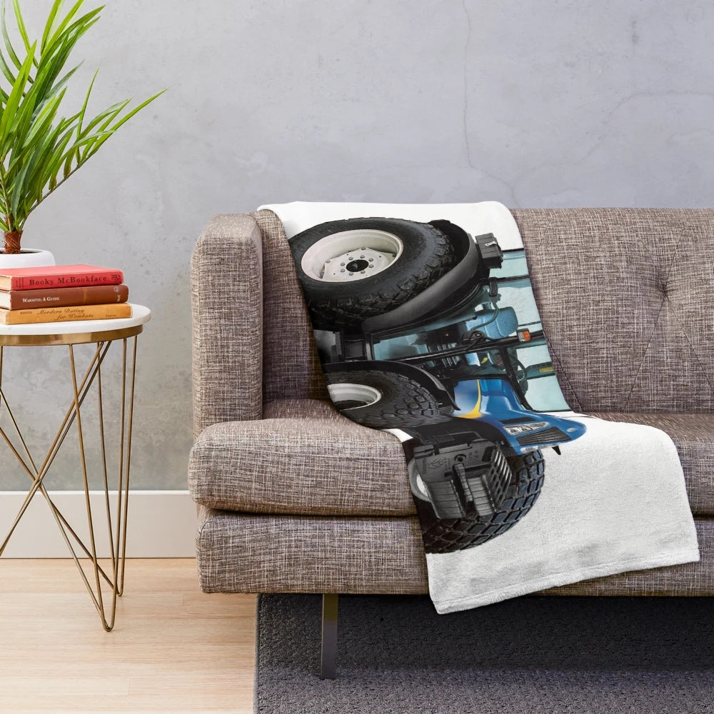 A soft and plush blue blanket featuring a tractor design, perfect for adding farmhouse style to your home.