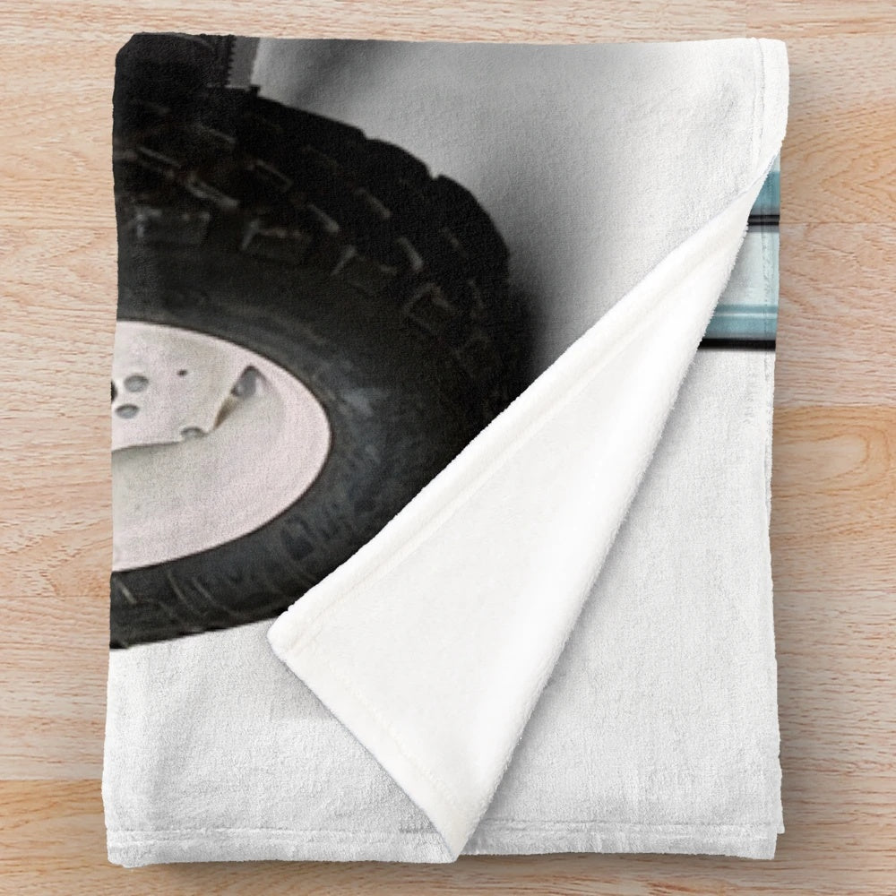 A soft and plush blue blanket featuring a tractor design, perfect for adding farmhouse style to your home.