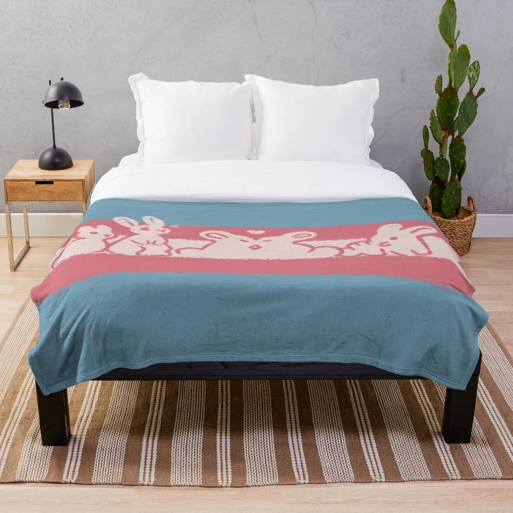 Soft and snuggly plush blanket featuring a transgender pride flag design with a cute rabbit bun