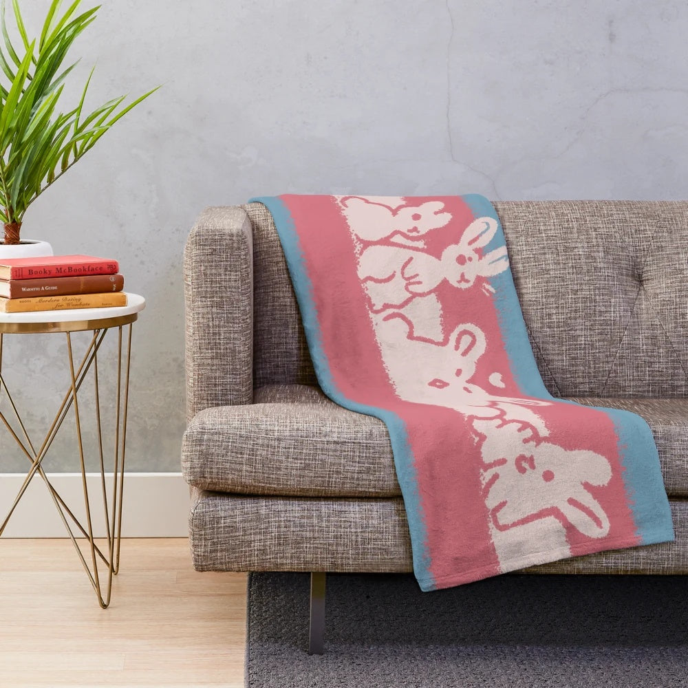 Soft and snuggly plush blanket featuring a transgender pride flag design with a cute rabbit bun