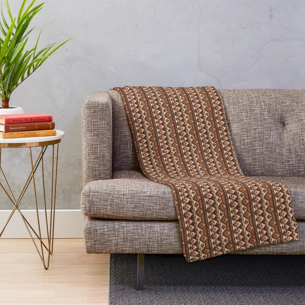 Plush blanket featuring a geometric pattern of indigenous trees