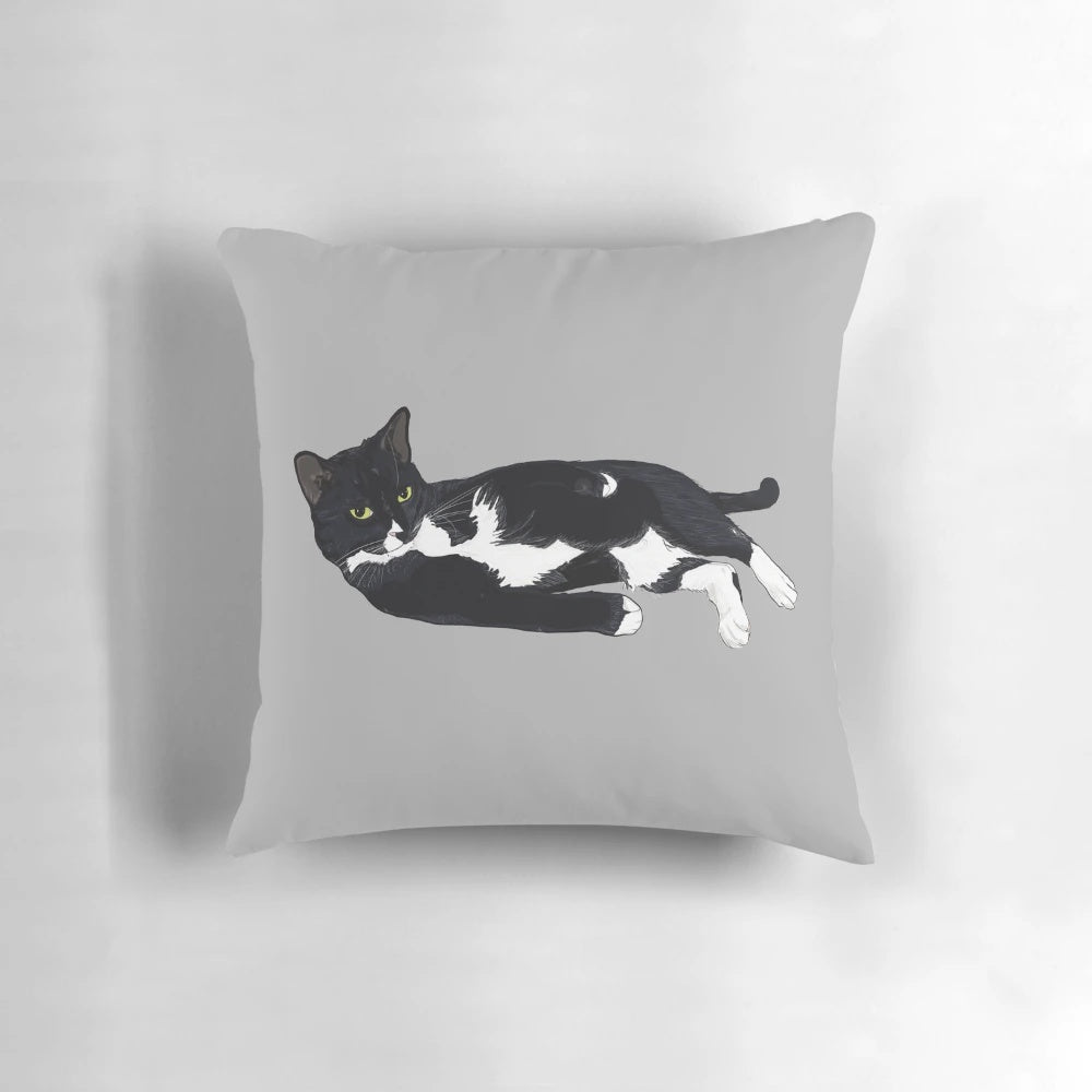 Soft, plush pillow featuring a sleeping tuxedo cat in a comfortable lounging pose