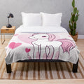 Soft and cuddly pink plush blanket featuring whimsical unicorns and hearts