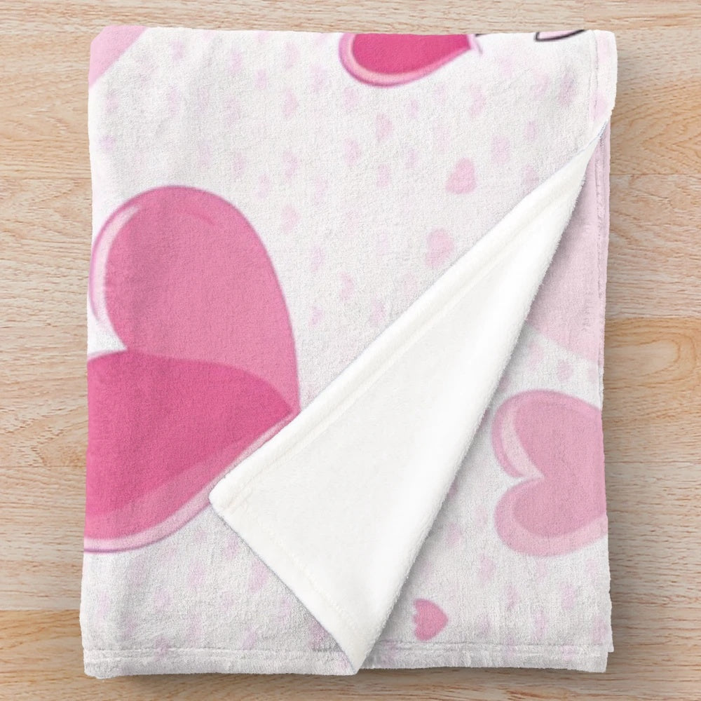 Soft and cuddly pink plush blanket featuring whimsical unicorns and hearts