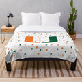 University of Miami Hurricanes logo on a plush orange and green blanket