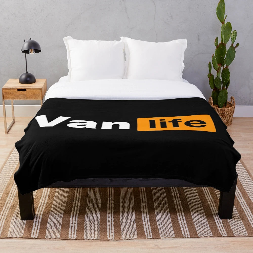 Plush black and orange blanket with van life graphics for outdoor enthusiasts