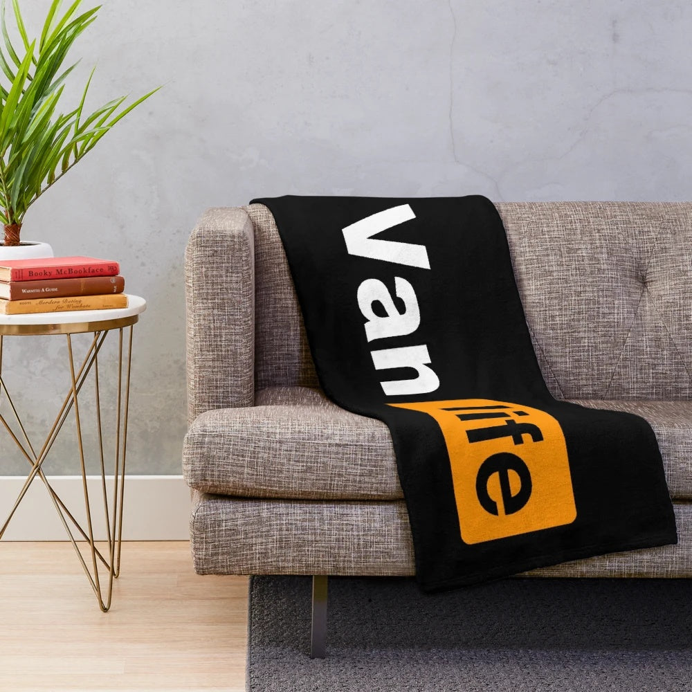 Plush black and orange blanket with van life graphics for outdoor enthusiasts