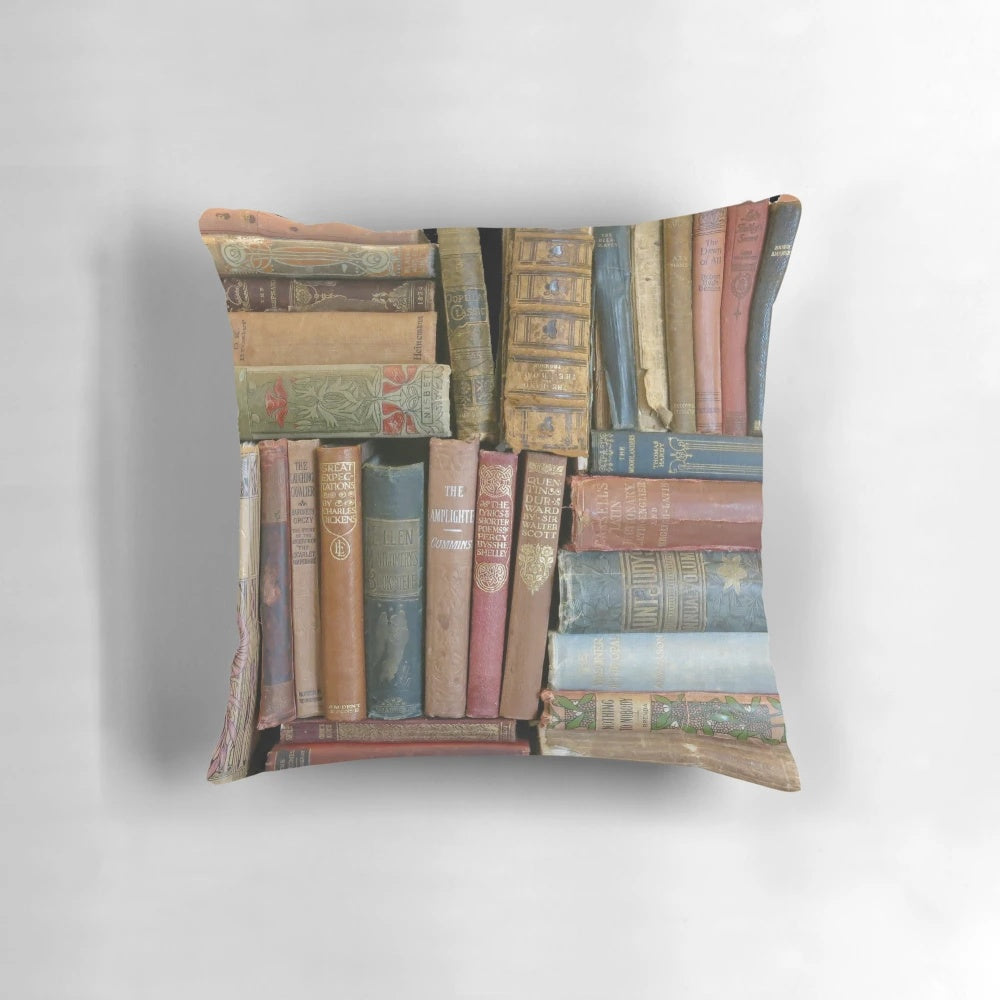 Vintage-style pillow featuring stacks of antique books and book spines in a cozy, rustic design