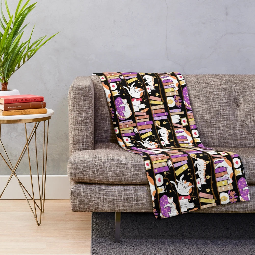 Violet plush blanket with a cute cat design, perfect for a cozy reading nook