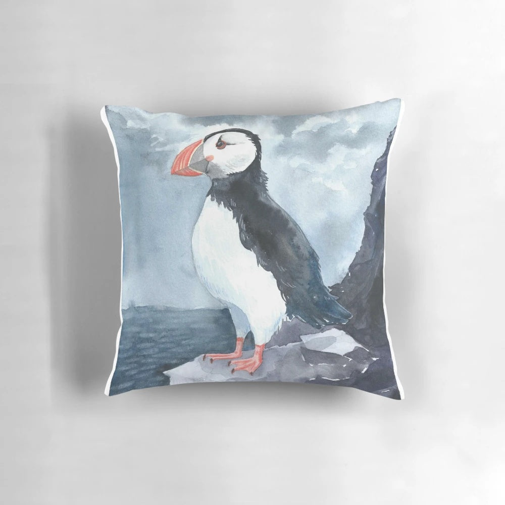 Soft, plush pillow featuring a beautiful watercolor painting of a puffin bird, perfect for adding a touch of Icelandic charm to your home.