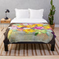 Watercolor painting of a pumpkin and floral bouquet on a soft, plush blanket