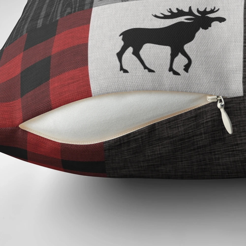 A vibrant red, black, and grey patchwork pillow with a woodland animal design, perfect for a rustic cabin or lodge.