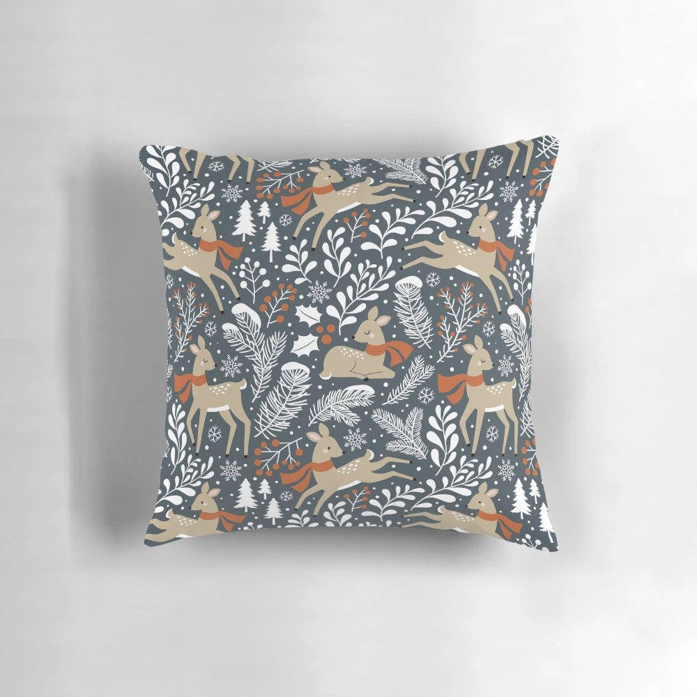 Dark grey pillow featuring a winter deer motif in a snowy forest setting