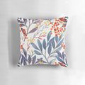 A close-up image of a plush, decorative winter pillow featuring a delicate floral and botanical design in shades of blue and beige.