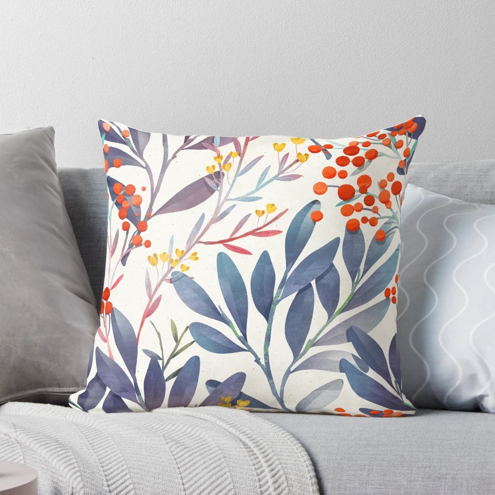 A close-up image of a plush, decorative winter pillow featuring a delicate floral and botanical design in shades of blue and beige.