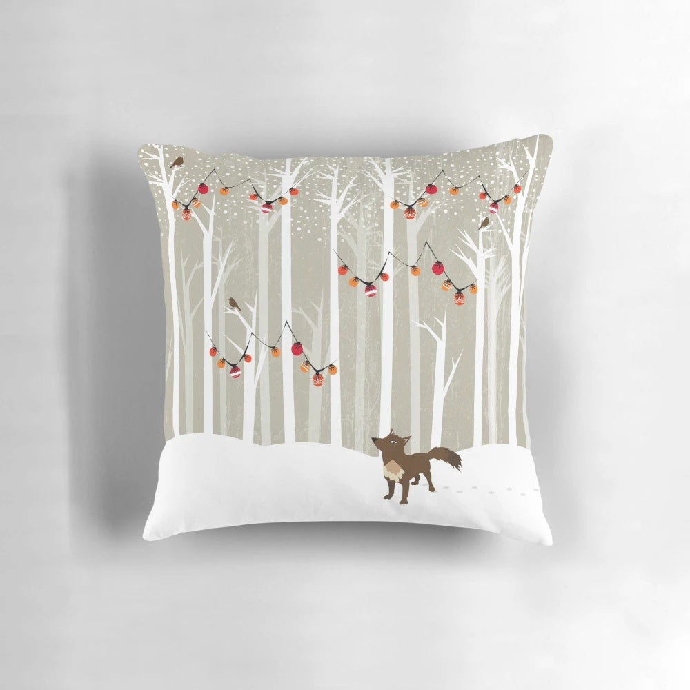 A cozy winter landscape pillow featuring a snowy forest scene with a majestic wolf and festive Christmas tree.