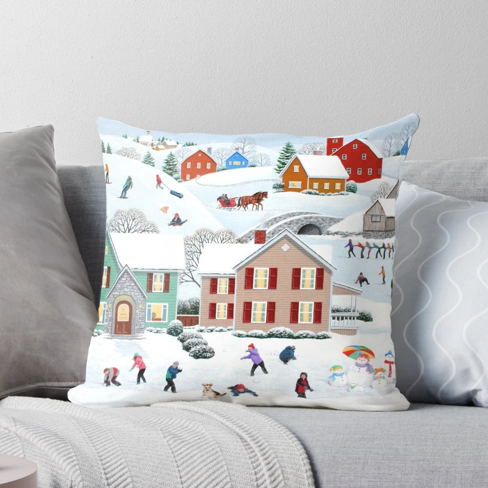 A soft, plush pillow featuring a winter scene with a snowman, trees, and a house in the snow.