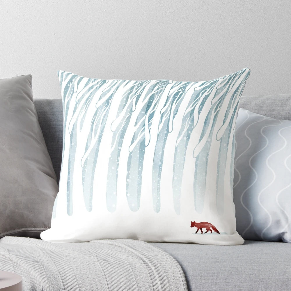 A plush, decorative pillow featuring a winter forest scene with a fox, branches, and snow.