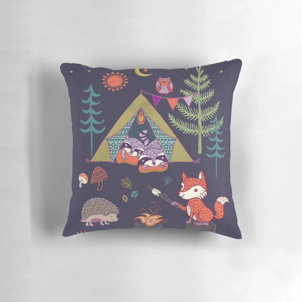 A plush pillow featuring a whimsical design of woodland animals like foxes, hedgehogs, and owls in a camping scene.