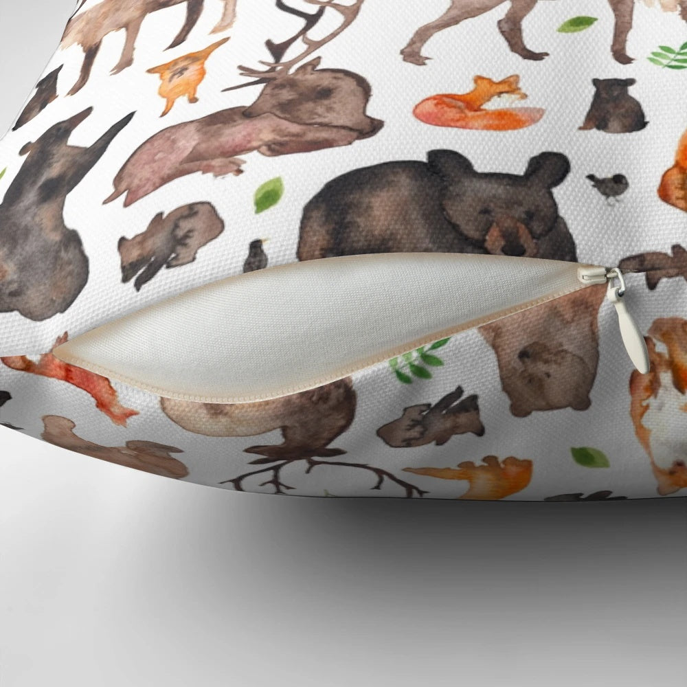 A decorative throw pillow featuring a watercolor pattern of woodland animals like foxes, bears, and deer.