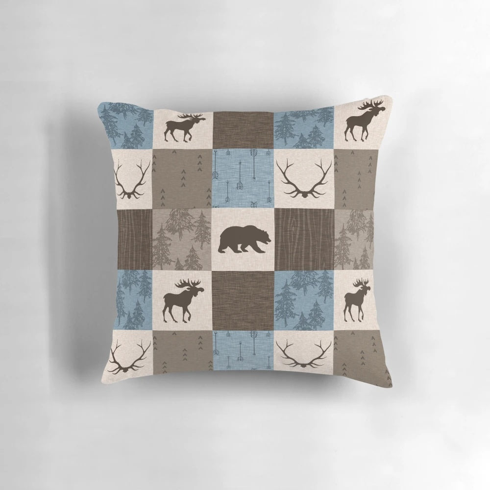 Decorative blue, brown, and beige patchwork pillow with woodland animal designs