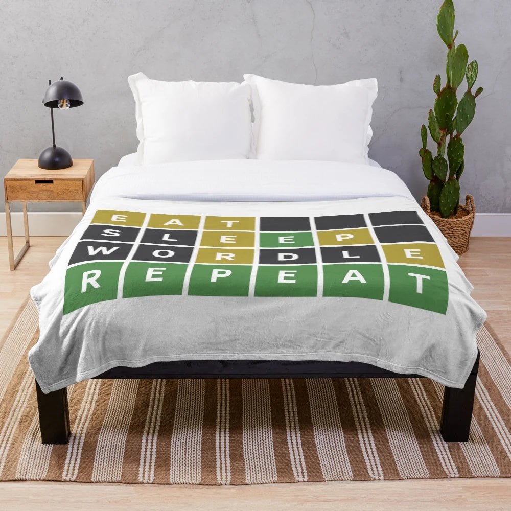 Wordle-themed plush blanket with green, yellow, and gray squares