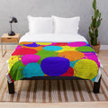 Colorful plush blanket featuring a playful design of yarn balls