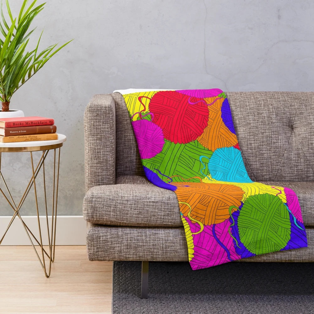 Colorful plush blanket featuring a playful design of yarn balls