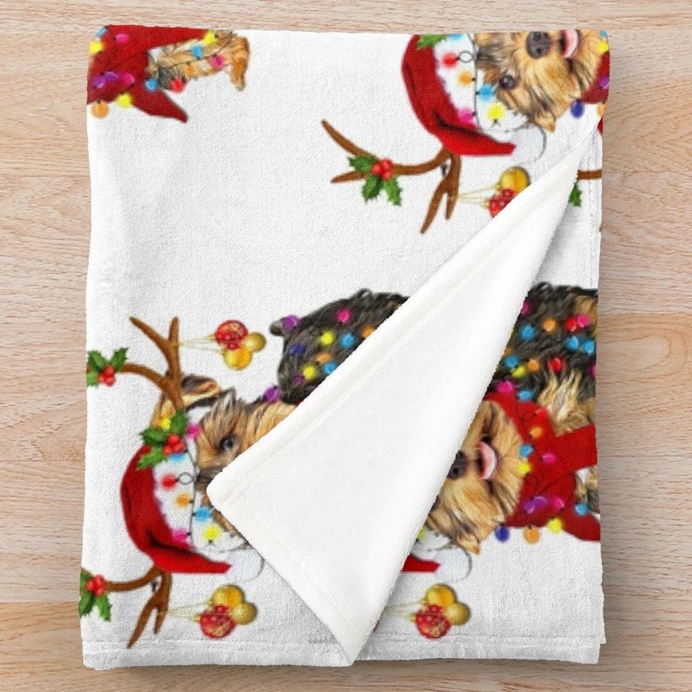 Yorkie terrier dog wrapped in a plush blanket with a Christmas reindeer hat